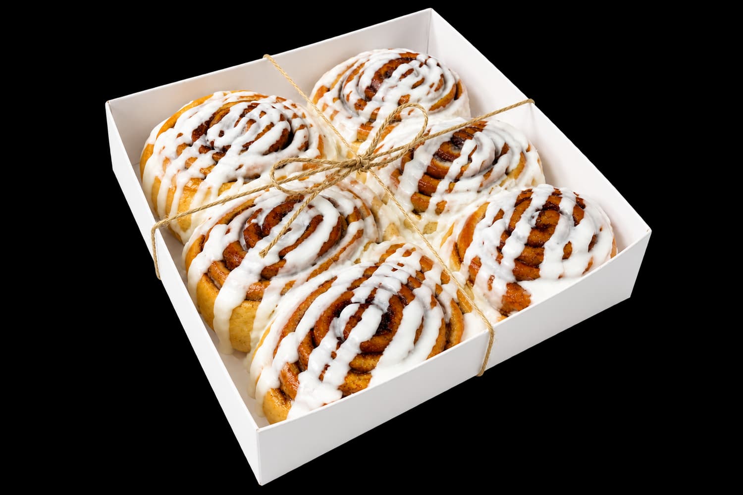 Six freshly iced cinnamon buns packed for delivery in Yerushalayim